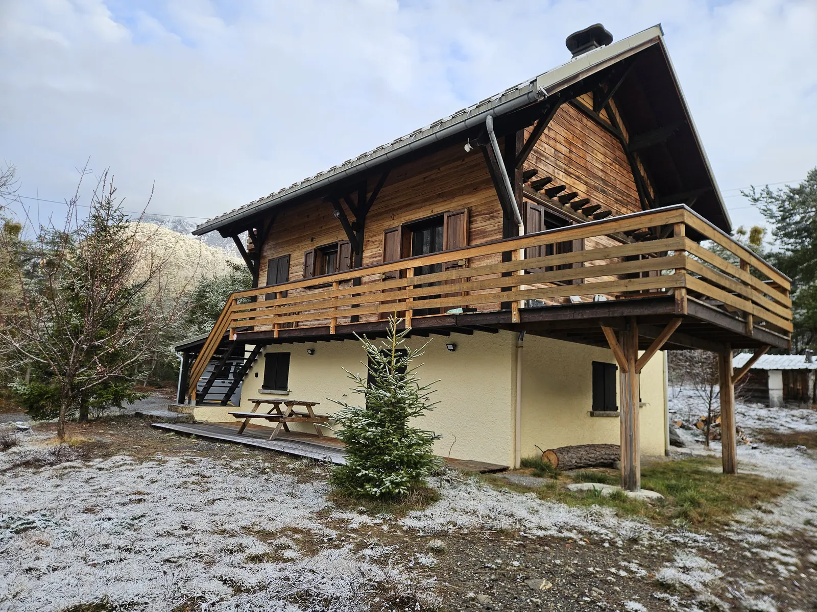 Grande terrasse en bois courant le long de la façade du chalet