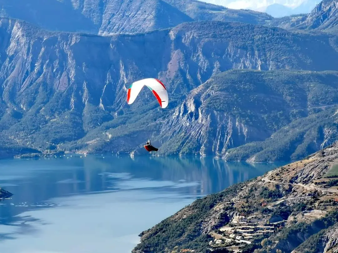Vue aérienne du lac de Serre-Ponçon avec un parapente
